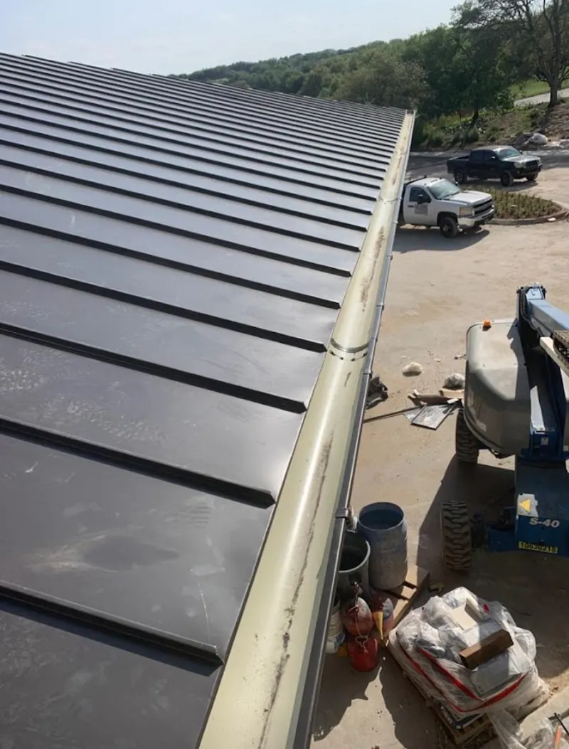Standing seam panel and gutter detail on a metal roofing jobsite in Fox Point